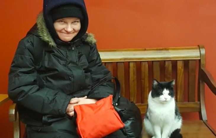 señora en la banca con gatita oreo