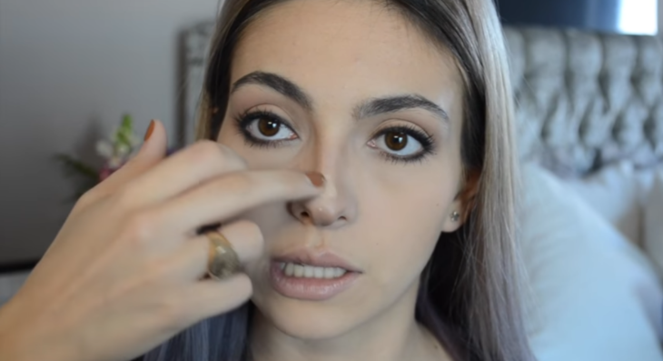 mujer blanca maquillando su nariz 