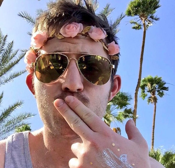 hombre con lentes y corona de flores 