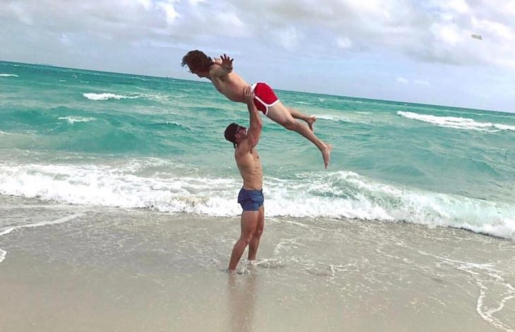 hombre cargando a hombre en la playa 