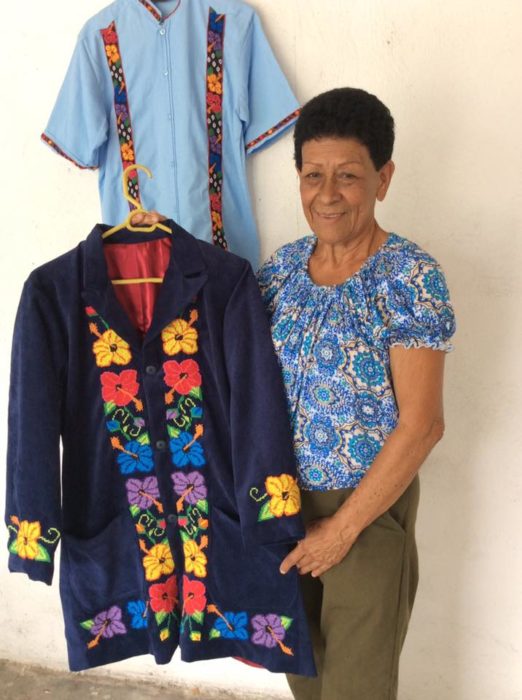 mujer con traje bordado azul con flores 