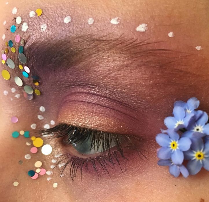 Chica con los ojos maquillados con flores 