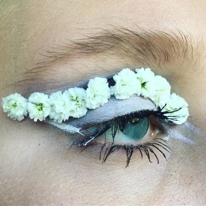 Chica con los ojos maquillados con flores 
