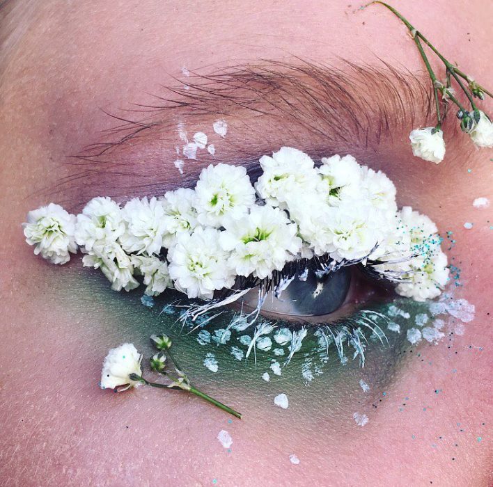 Chica con los ojos maquillados con flores 