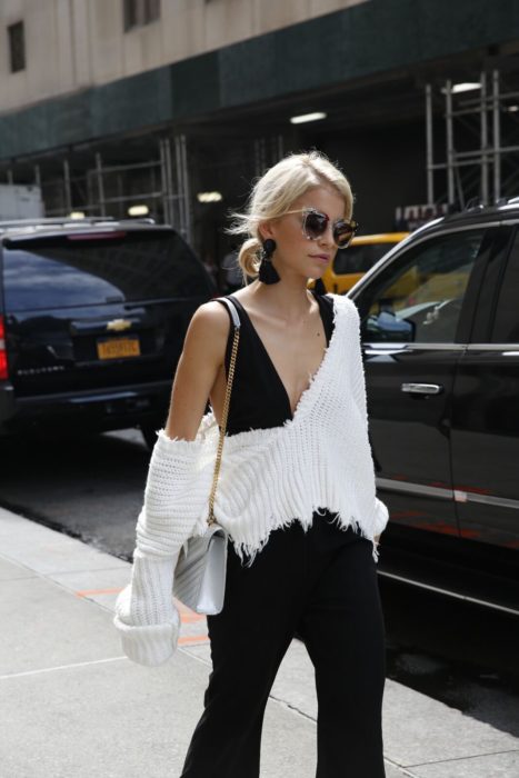 Chica usando un crop top color negro y aretes grandes de color negro 