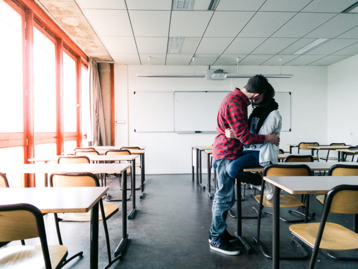 pareja beso escuela