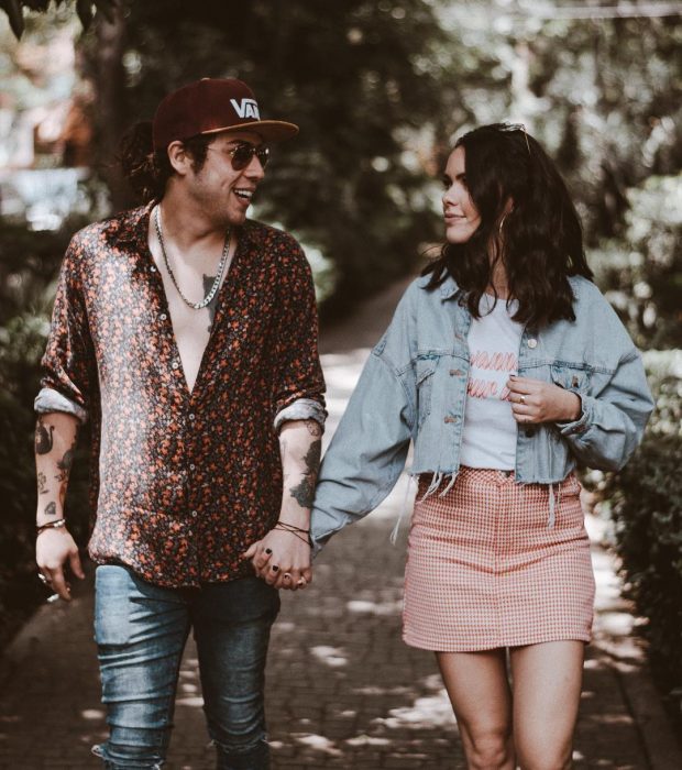 hombre rubio con lentes y gorra con mujer con falda 