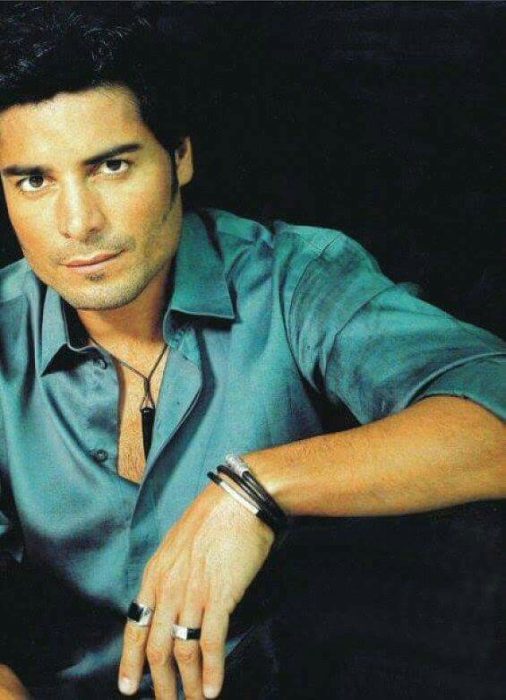 Chayanne sentado al filo de unas escaleras con los brazos cruzados