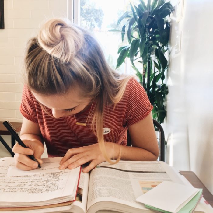 Chica escribiendo en un alibreta 