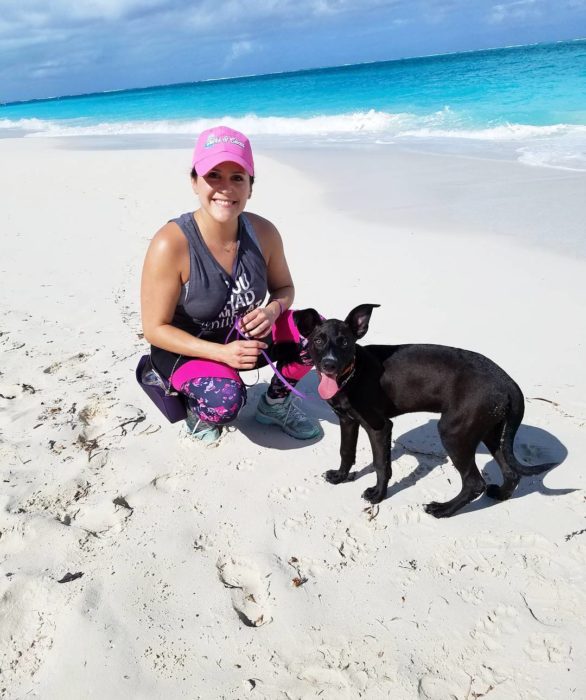 Mujer jugando con un perro en la playa 