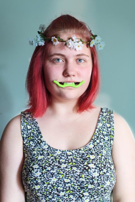 mujer con corona de flores y aparato en su boca
