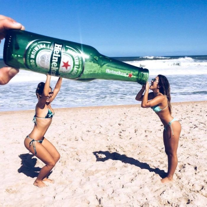 chicas sosteniendo una cerveza gigante