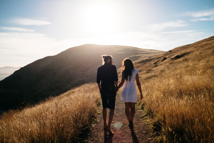 pareja caminando por pastizales