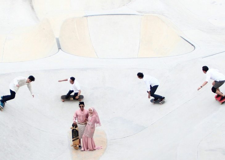 pareja de recien casados rodeada de patinadores