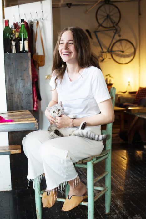 Chica con gato gris en las piernas