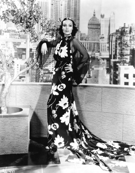 Dolores del Río usando vestido negro largo con flores blancas