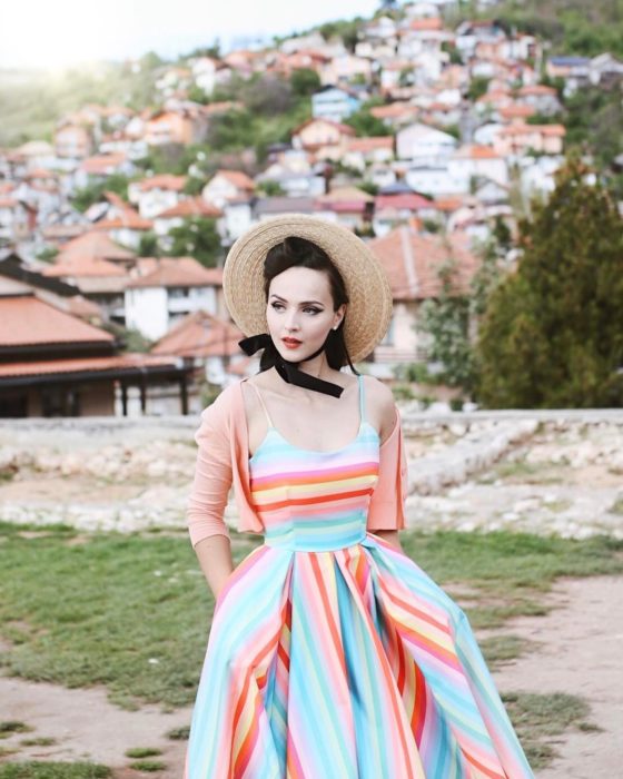 mujer blanca con vestido azul de rayas