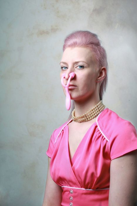 mujer con cabello rosa y aparato rosa en la nariz