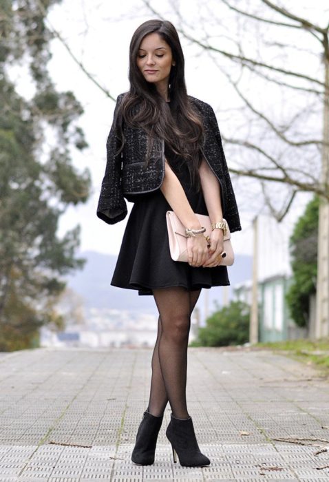 Chica usando botines con medias negras y vestido 