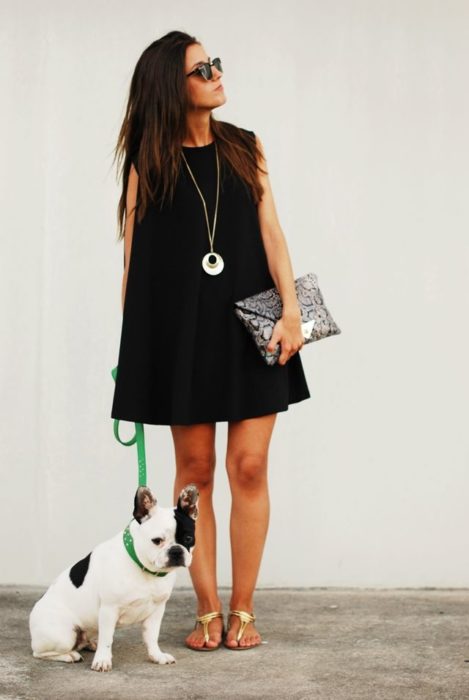 Chica usando un vestido negro y clutch de lentejuelas