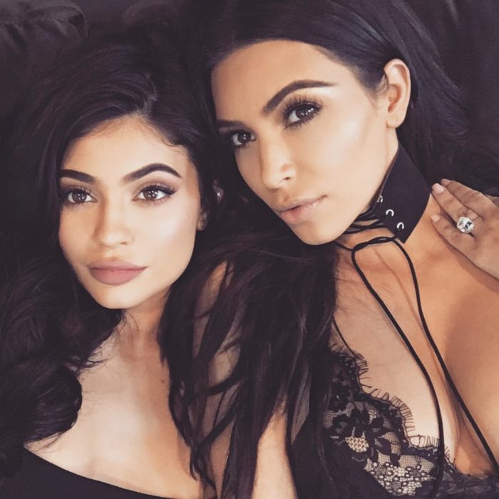 Kim Kardashian y Kylie jenner recostadas en una cama 