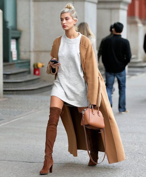 Chica usando un look con sudadera y botas largas