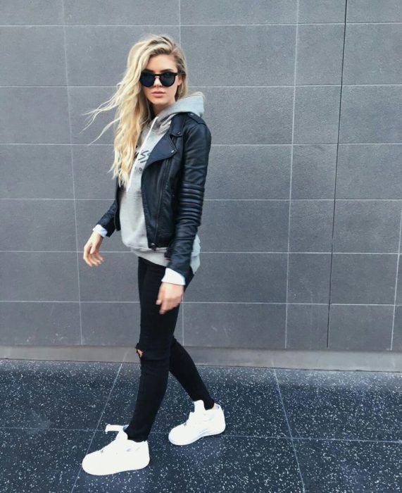 Chica usando un look con sudadera y chamarra de 