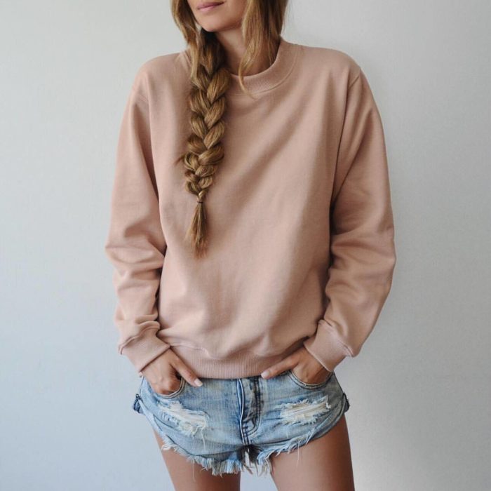 Chica usando un look con sudadera y shorts 