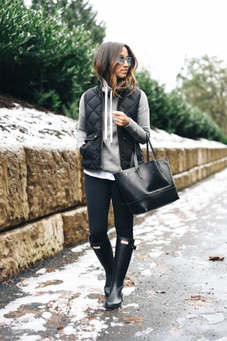 Chica usando un look con sudadera, jeans y botas de lluvia