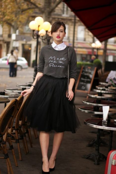 Chica usando un look con sudadera y falda 