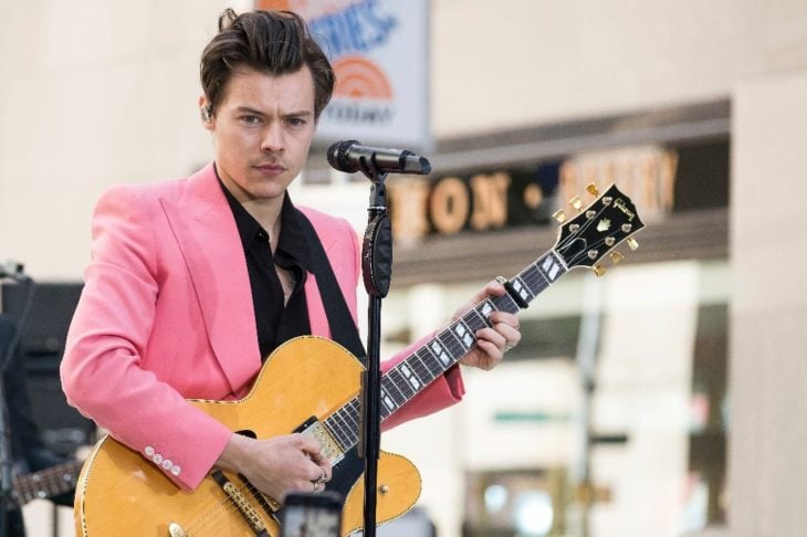 Harry Styles tocando la guitarra en un centro comercial