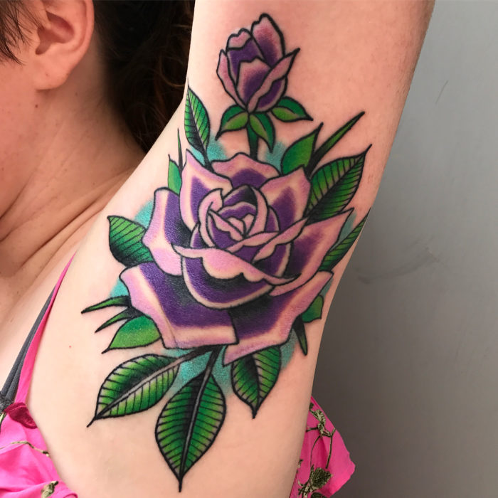 Chica con un tatuaje en la axila de una flor 