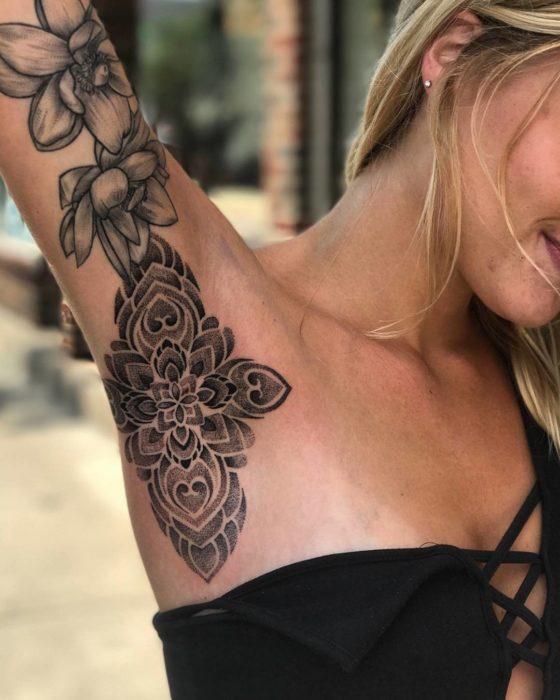 Chica con un tatuaje en la axila de una flor 