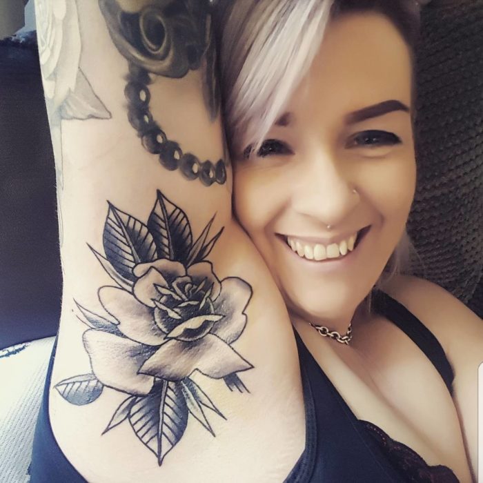 Chica con un tatuaje en la axila de una flor 