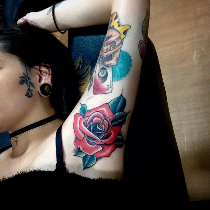 Chica con un tatuaje en la axila de una flor 