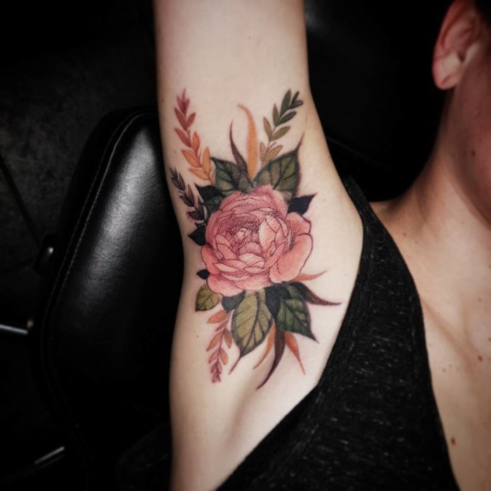 Chica con un tatuaje en la axila de una flor 