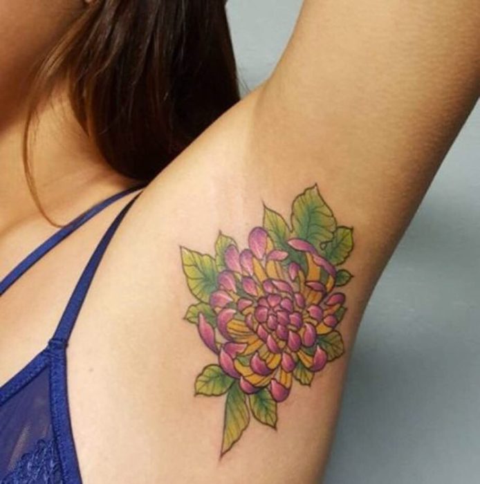 Chica con un tatuaje en la axila de una flor 