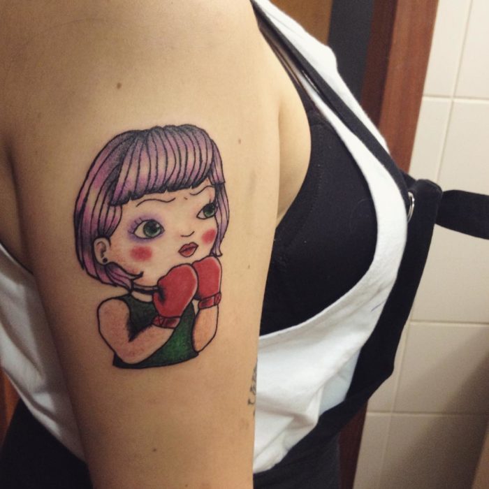 Tatuaje feminista de una muñeca peleando 