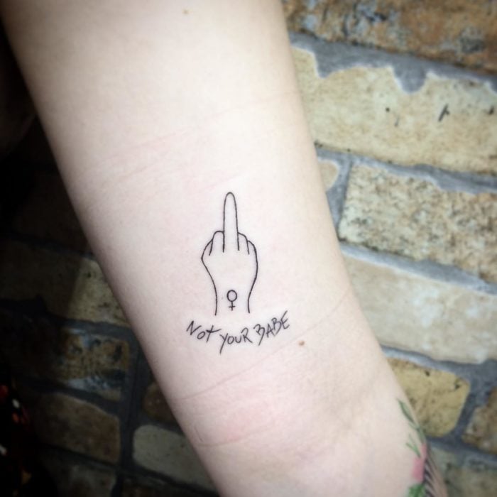 Tatuaje feminista de una mano levantando el dedo medio 