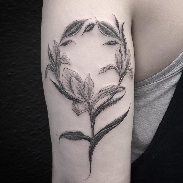 Tatuaje feminista de flores formando el símbolo de la mujer 