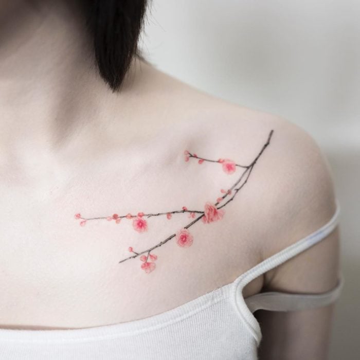 chica con tatuaje de flor de cerezo