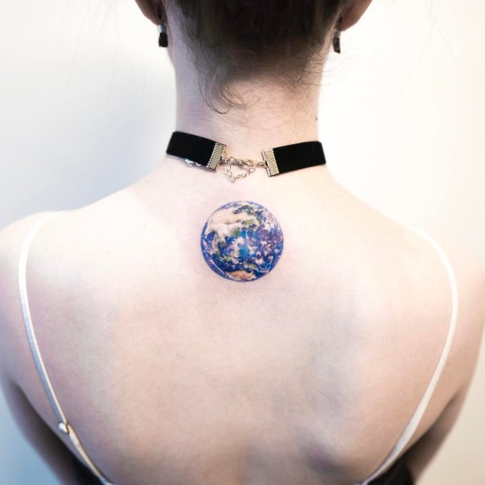 chica con tatuaje del planeta tierra 