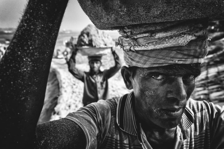 hombre cargando arena en Munshiganj, Bangladesh