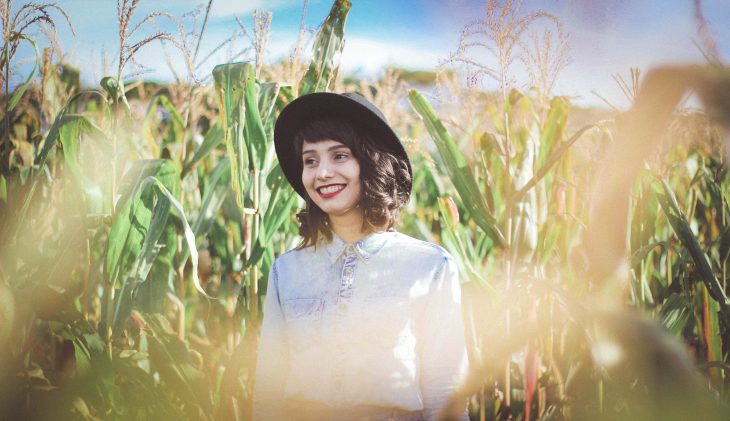 chica sonriendo en un campo de maiz