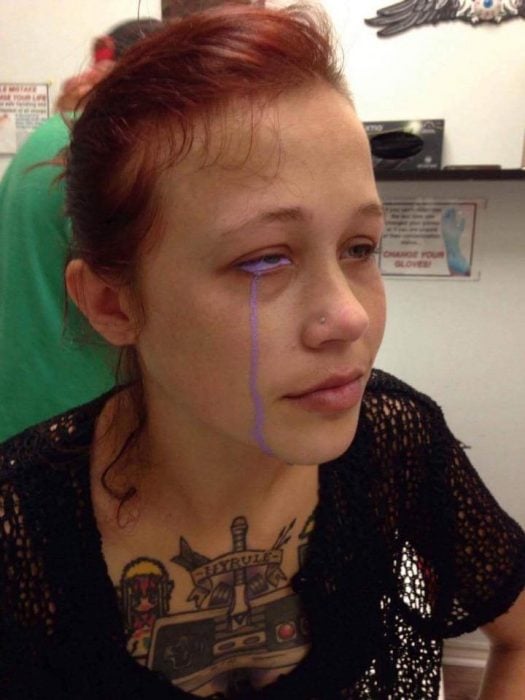 mujer pelirroja con ojo morado llorando tinta morada 
