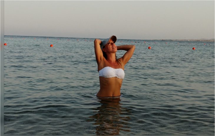 mujer con gorra en el mar