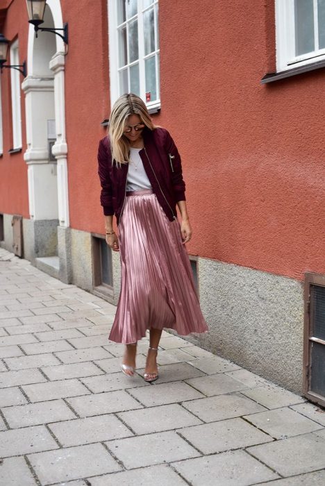 Chica usando una bomber jacket guinda con falda tableada 