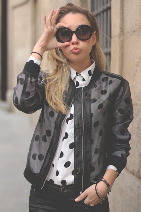 Chica usando una bomber jacket negra con transparencias 