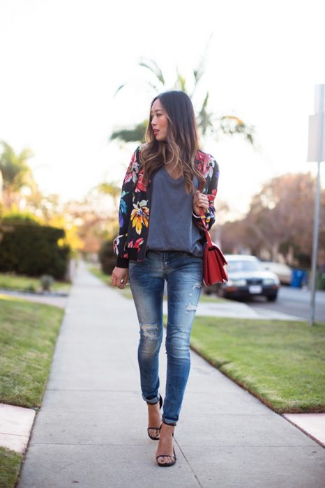 Chica usando una bomber jacket negro con estampados florales 