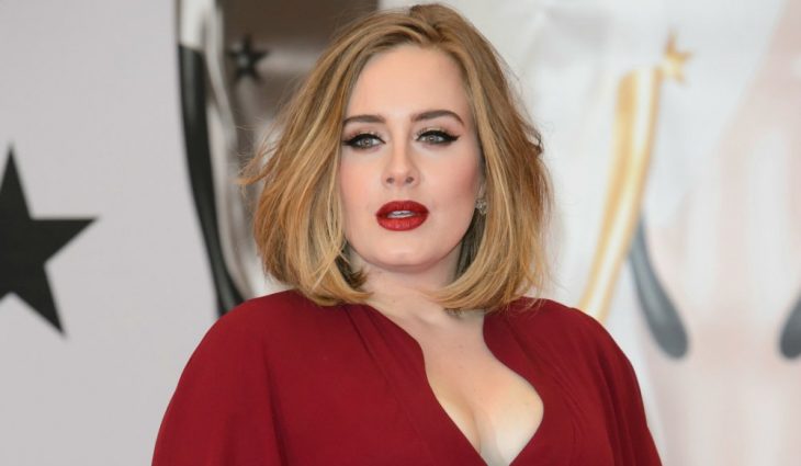 Adele posando para una fotografía durante una alfombra roja 